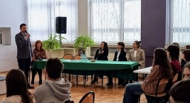 Mężczyzna prowadzi prezentację przed grupą słuchaczy w sali konferencyjnej