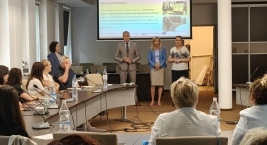 grupa ludzi wsłuchana w osoby rozpoczynające spotkanie