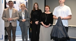 Przedstawiciele organizatorów i uczestnik spotkania pozują do zdjęcia po wręczeniu certyfikatu „szkoły przyjaznej ekonomii społecznej”.